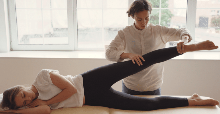 Physiotherapeutin mobilisiert Bein einer Patientin bei Physiotherapie in Hamburg