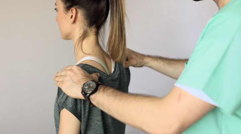 Physiotherapeut untersucht Haltung und Schulterbereich einer Patientin in Hamburg