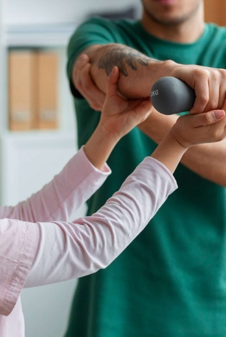 Physiotherapeut unterstützt Patient bei Armtherapie mit Trainingsgerät in Hamburg