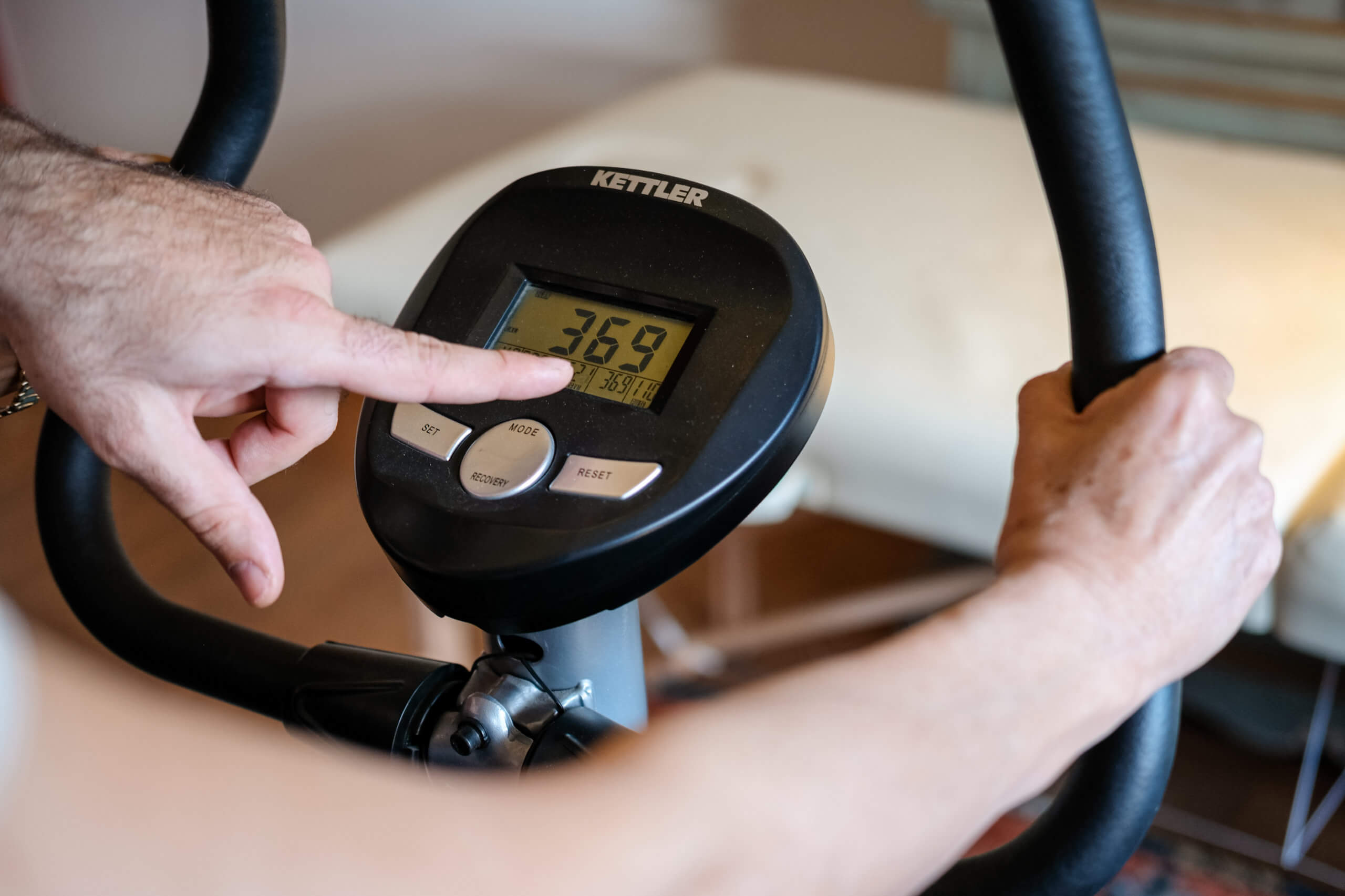 Patient stellt ein Ergometer für ein Training unter Anleitung eines mobilen Physiotherapeuten in Hamburg ein